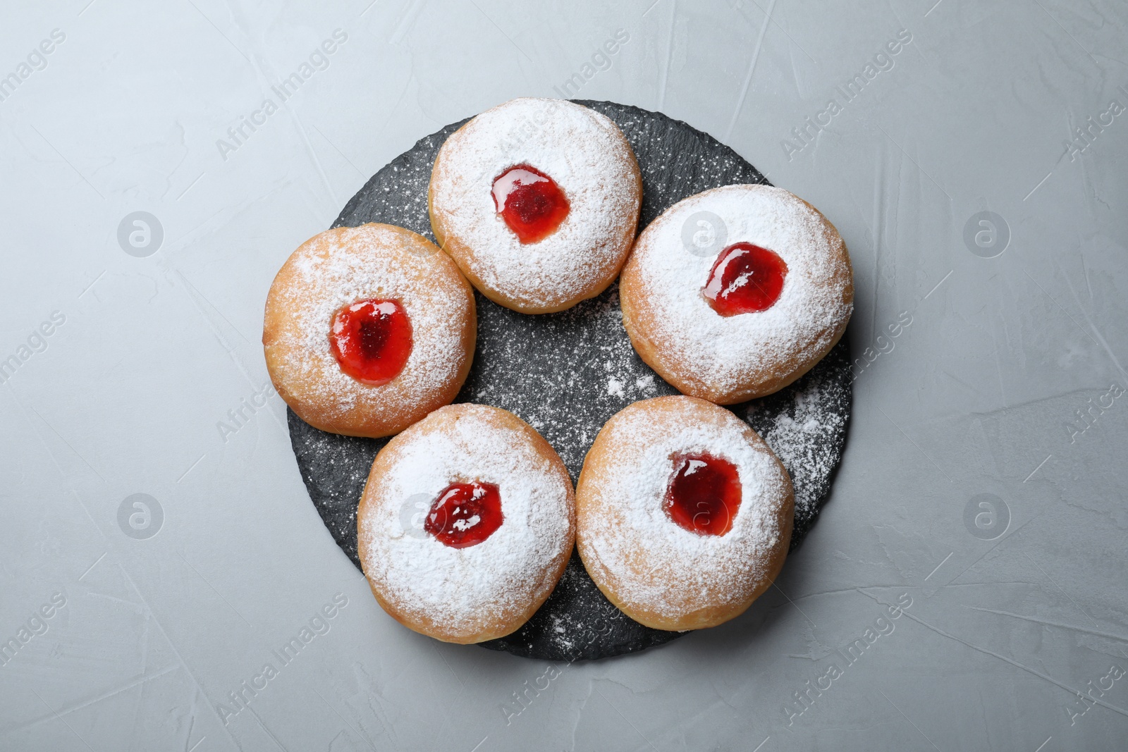 Photo of Hanukkah food doughnuts with jelly and sugar powder served on grey table, top view