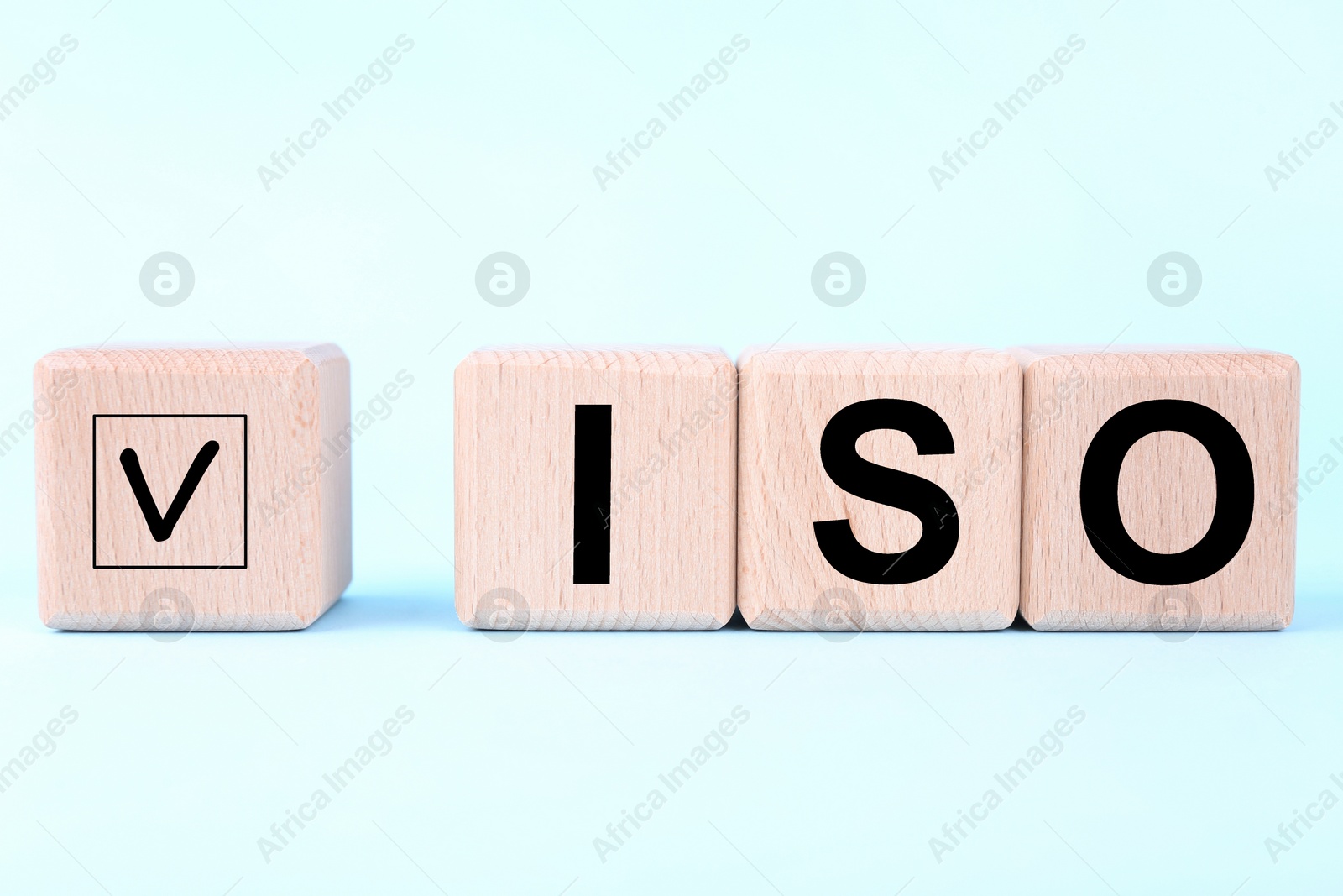Photo of International Organization for Standardization. Wooden cubes with check mark and abbreviation ISO on light blue background