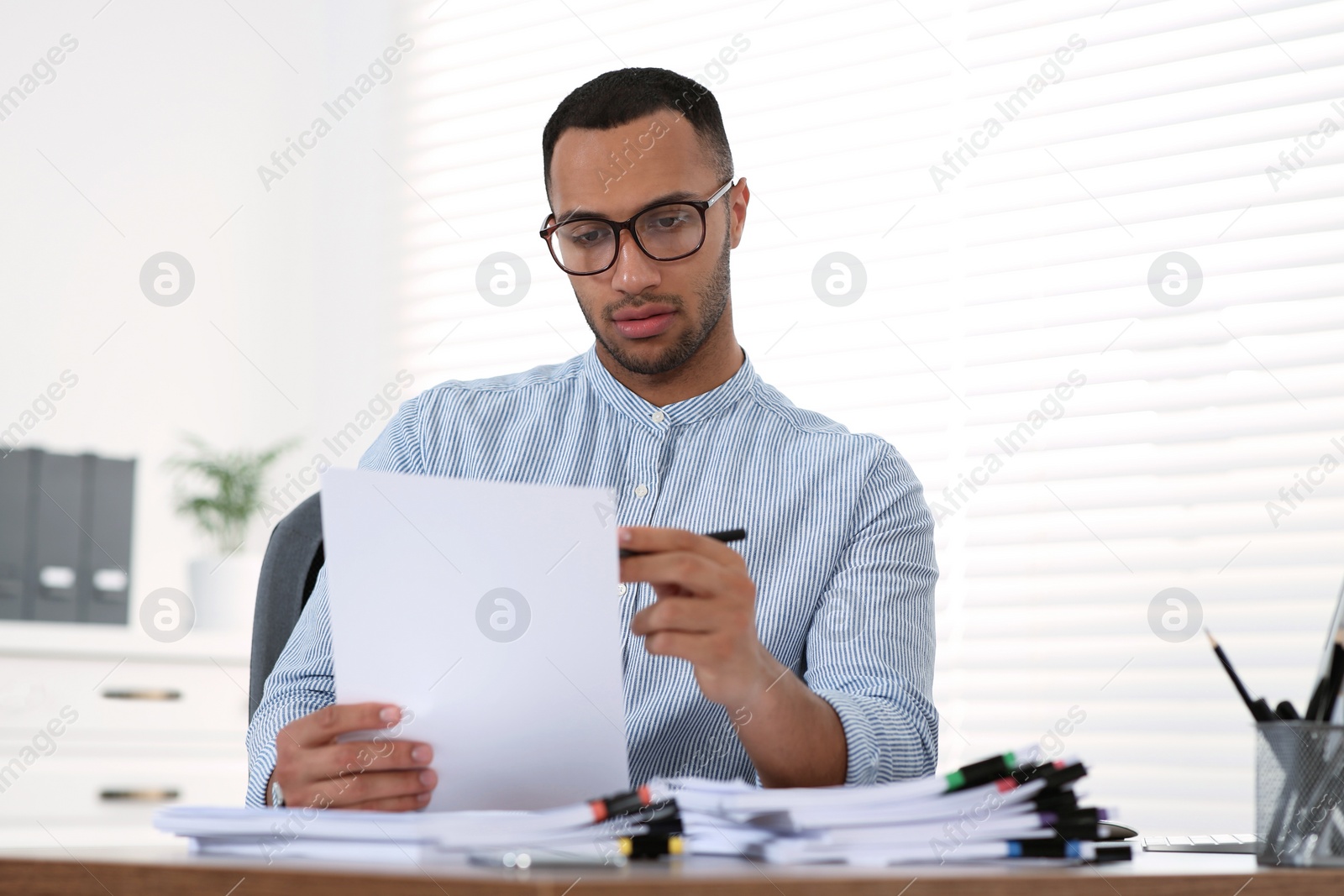 Photo of Businessman working with documents at wooden table in office