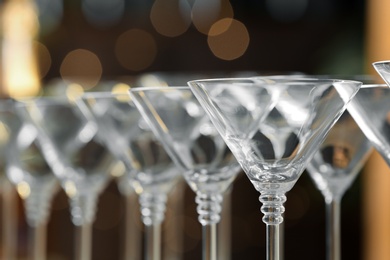 Photo of Empty martini glasses on blurred background, closeup