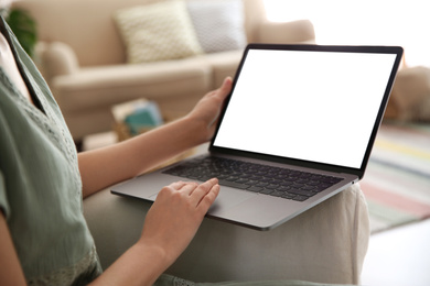 Photo of Woman using laptop at home, closeup. Space for design