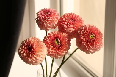 Photo of Bouquet of beautiful dahlia flowers in vase near window indoors