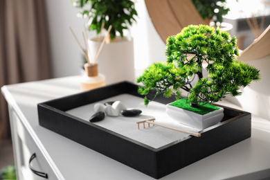 Photo of Beautiful miniature zen garden on white cabinet indoors