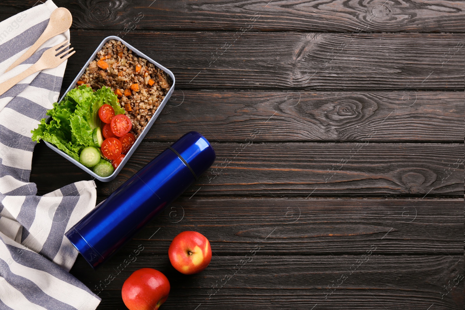 Photo of Flat lay composition with thermos and lunch box on black wooden background, space for text