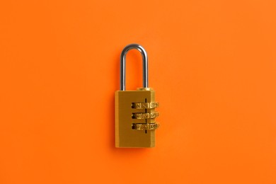 Photo of Modern combination lock on orange background, top view
