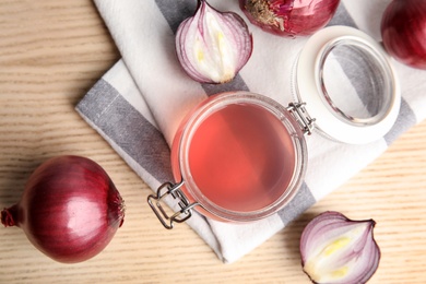 Flat lay composition with onion syrup in jar and ingredient on table