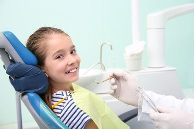 Professional dentist working with little patient in modern clinic