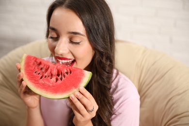 Beautiful young woman with watermelon on chair