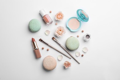 Photo of Flat lay composition with makeup products, roses and macarons on white background