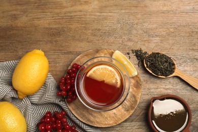 Flat lay composition with immunity boosting drink and ingredients on wooden table, space for text