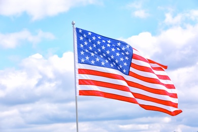 Photo of American flag outdoors on cloudy day. Space for text