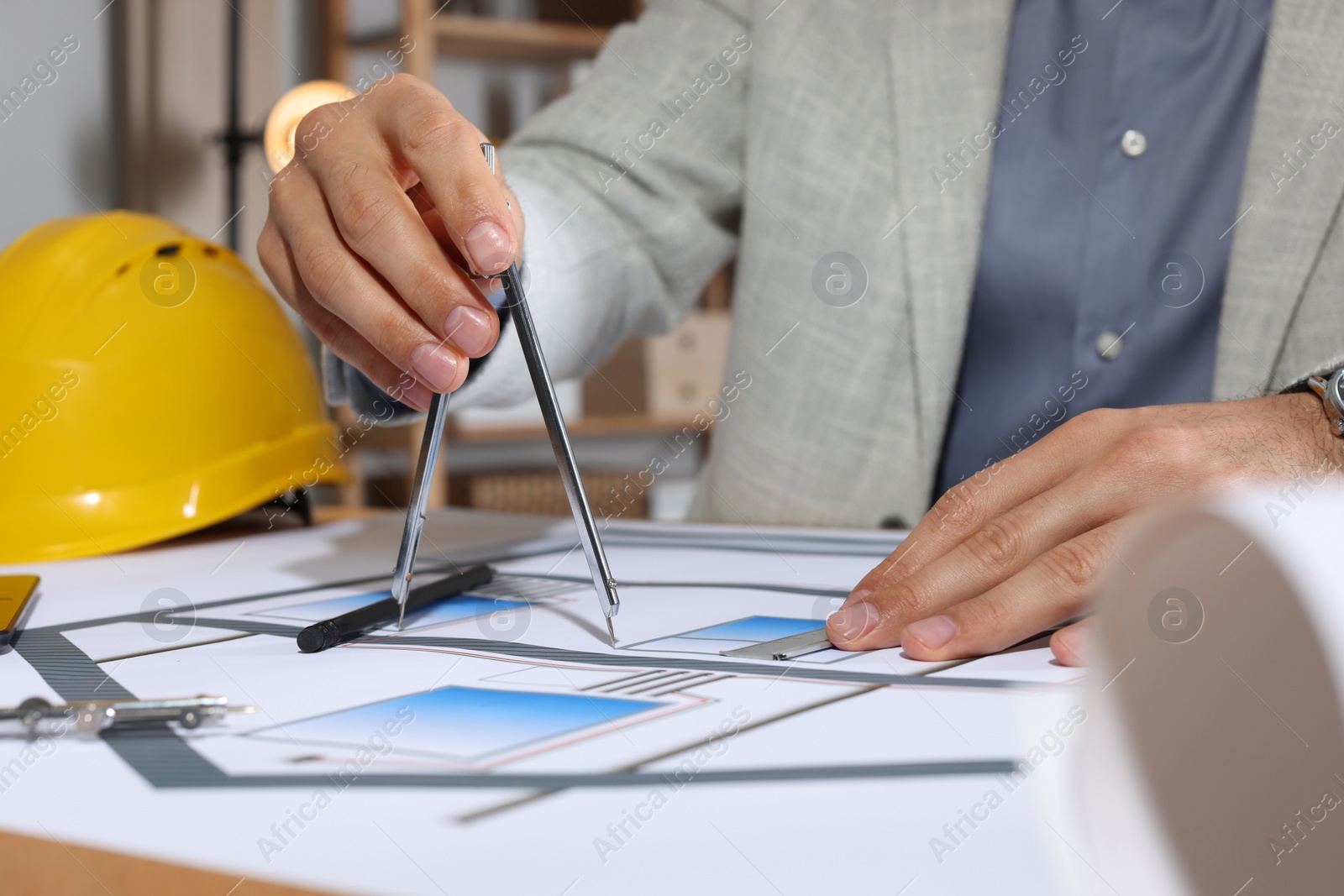 Photo of Architect working with construction drawings in office, closeup