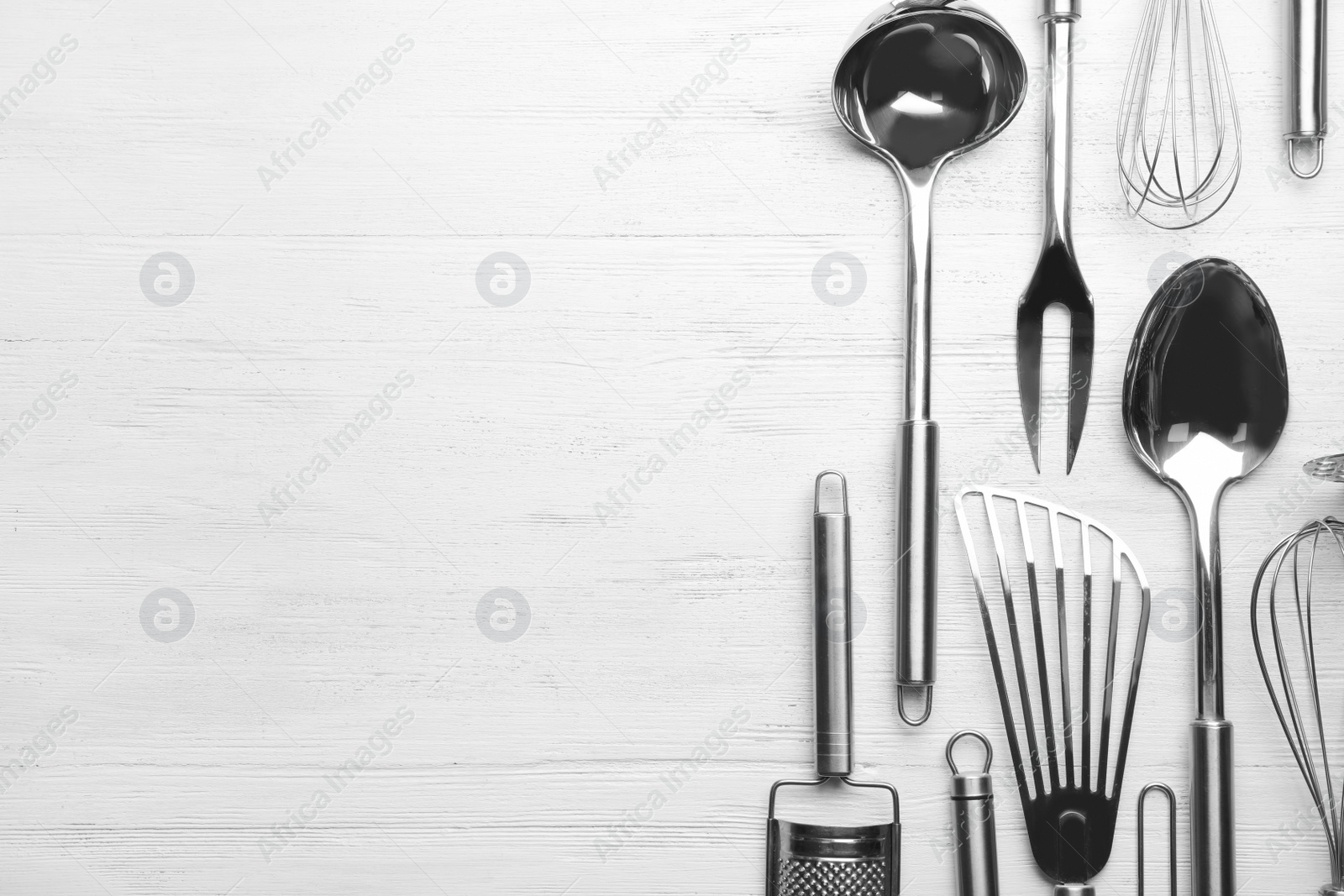 Photo of Different kitchen utensils on wooden background, top view with space for text