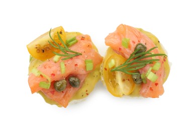 Tasty canapes with salmon, tomatoes, capers and herbs isolated on white, top view