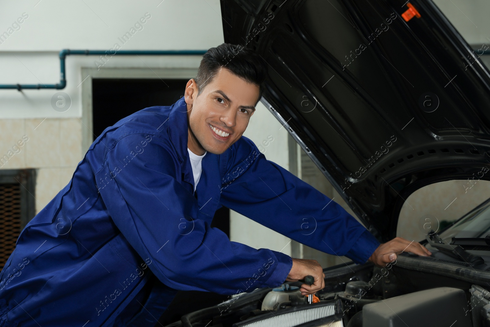 Photo of Professional mechanic fixing modern car at automobile repair shop