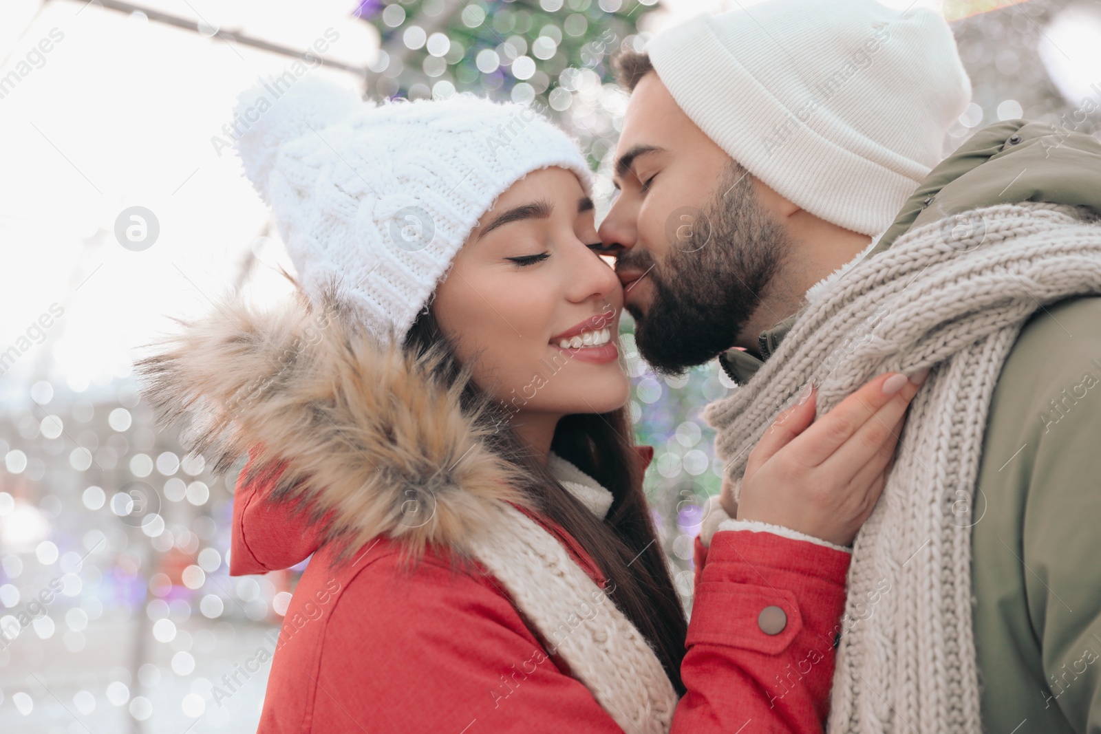 Photo of Happy young couple spending time together at winter fair. Christmas celebration