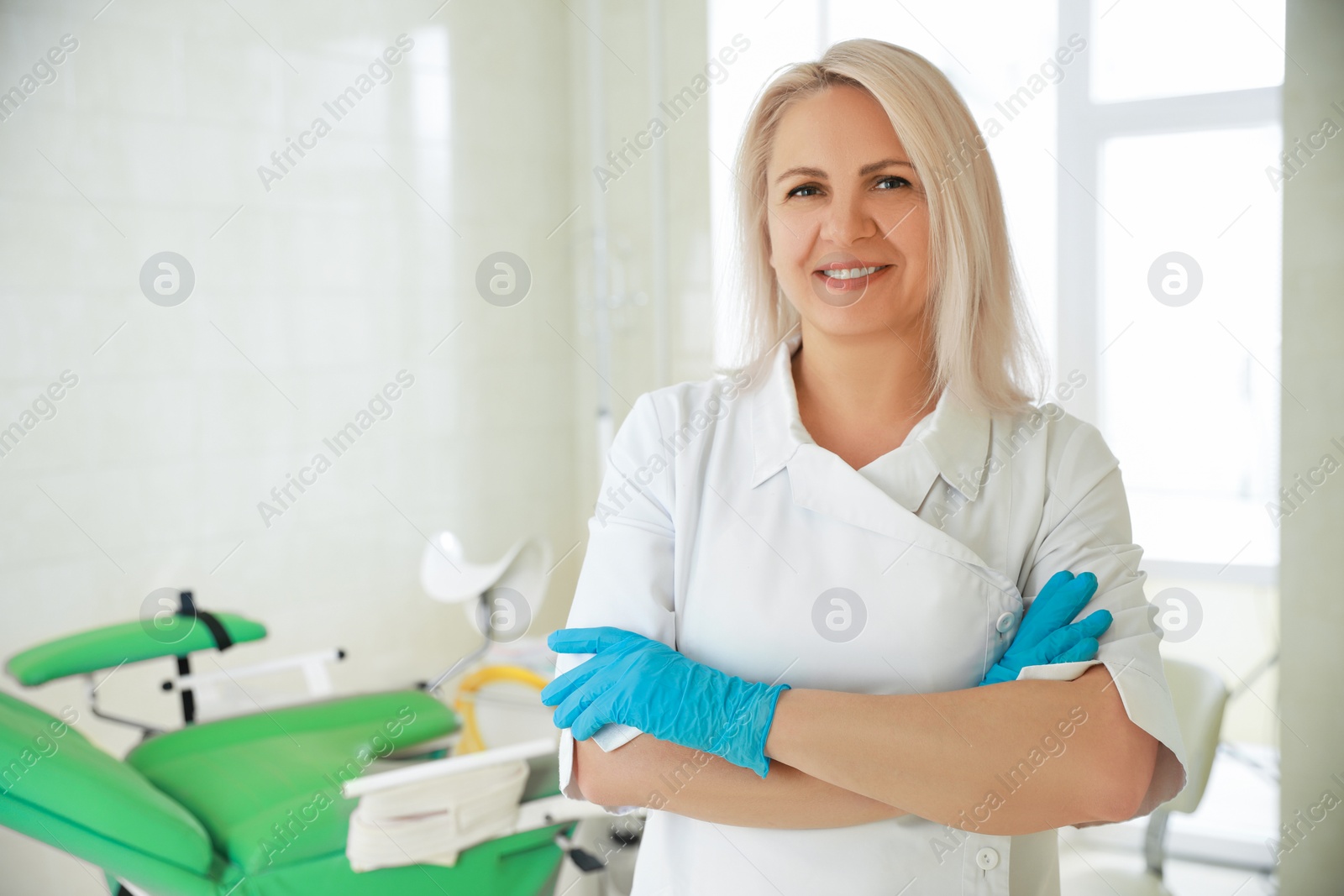 Photo of Portrait of smiling gynecologist at workplace in clinic. Space for text