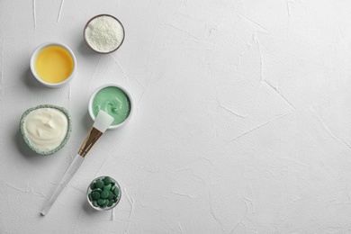 Photo of Flat lay composition with spirulina facial mask and ingredients on white table. Space for text
