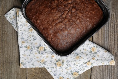 Homemade chocolate sponge cake on wooden table, top view