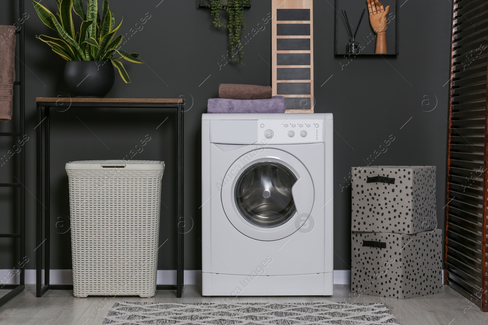 Photo of Stylish laundry room with washing machine. Interior design