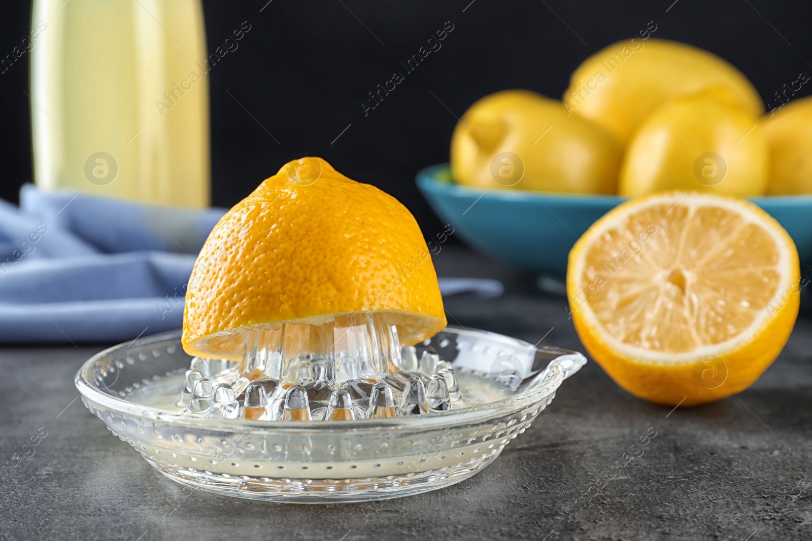 Photo of Glass juicer with lemon half on table. Refreshing drink recipe