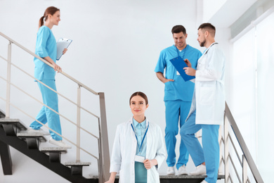 Team of professional doctors on staircase in clinic