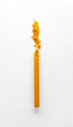 Glass tube with turmeric on white background, top view