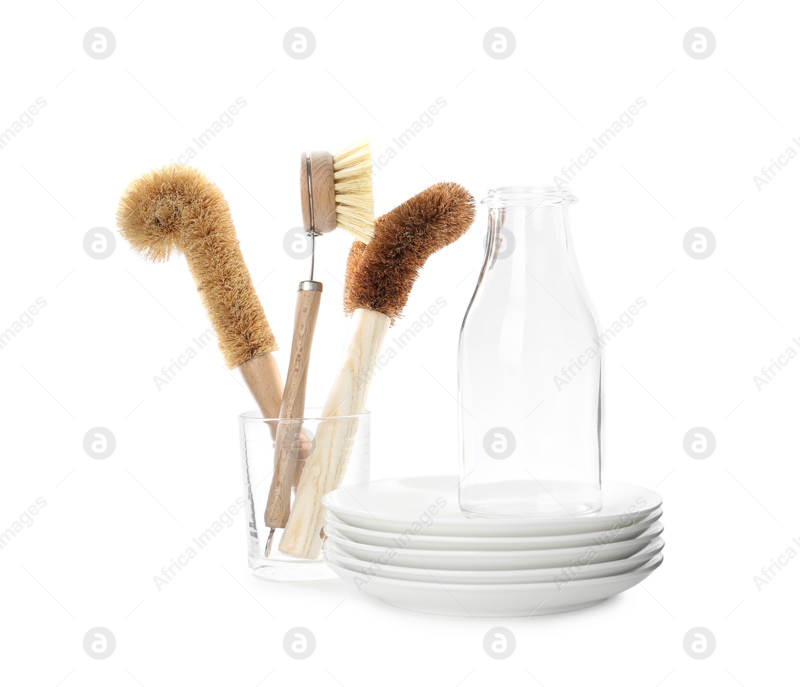 Photo of Cleaning brushes for dish washing, bottle and plates on white background