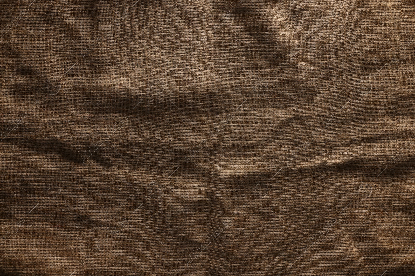 Photo of Texture of natural burlap fabric as background, top view