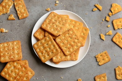 Photo of Delicious crispy crackers on grey table, flat lay