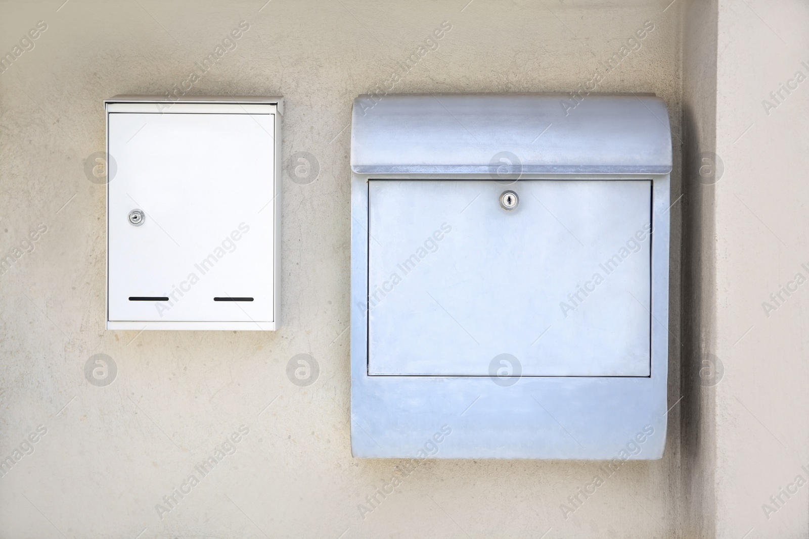 Photo of White metal letter boxes on beige wall