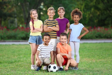 Cute little children with soccer ball in park. Outdoor play