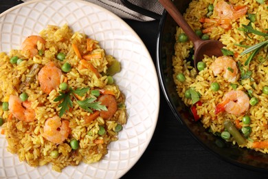 Tasty rice with shrimps and vegetables served on dark wooden table, flat lay