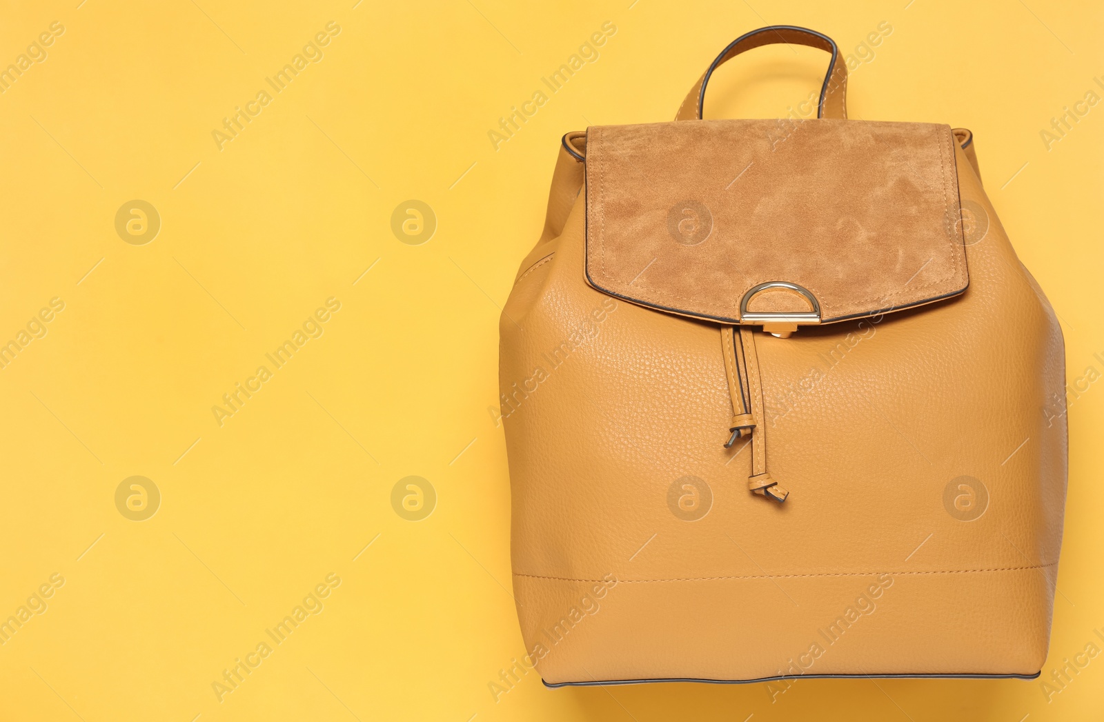 Photo of Stylish urban backpack on yellow background, top view. Space for text