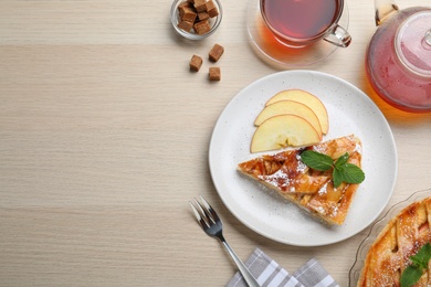 Photo of Slice of traditional apple pie served on wooden table, flat lay. Space for text