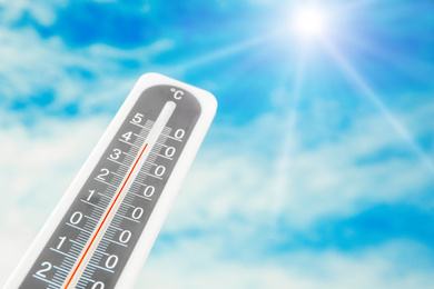 Image of Weather thermometer with high temperature and beautiful sky on background, space for text 