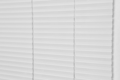Photo of Window with closed modern horizontal blinds indoors, closeup
