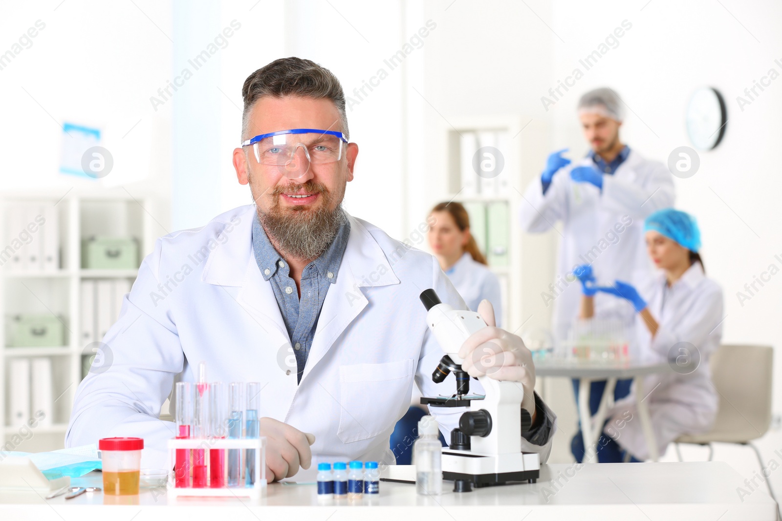 Photo of Portrait of male scientist at table in laboratory. Research and analysis