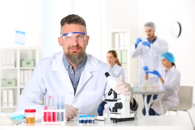 Photo of Portrait of male scientist at table in laboratory. Research and analysis