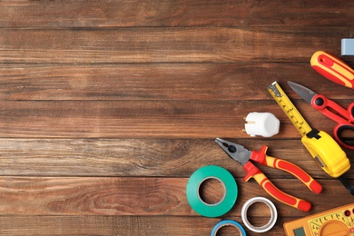 Flat lay composition with electrician's tools and space for text on wooden background