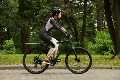 Photo of Young woman riding bicycle on road outdoors