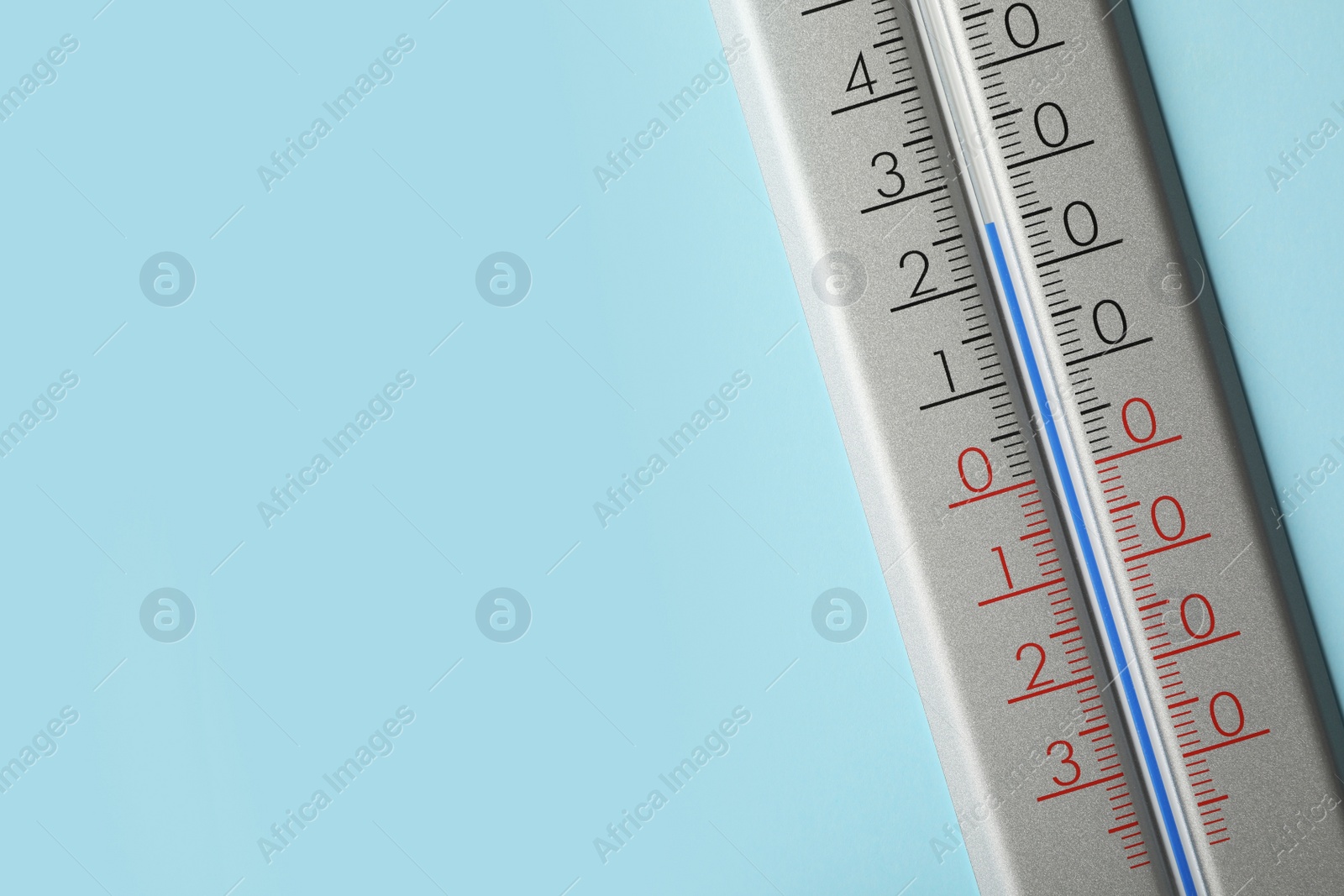 Photo of Weather thermometer on light blue background, closeup. Space for text