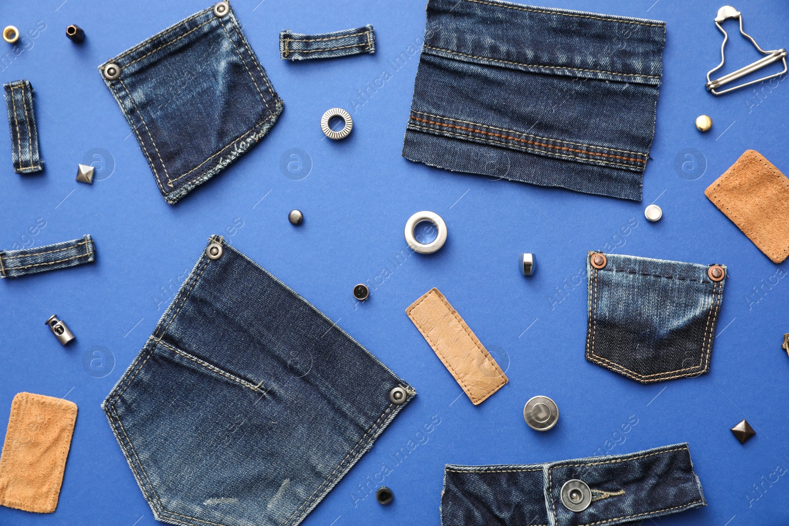 Photo of Flat lay composition with garment accessories and cutting details for jeans on blue background