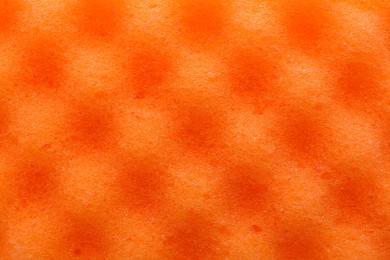 Photo of Orange cleaning sponge as background, top view