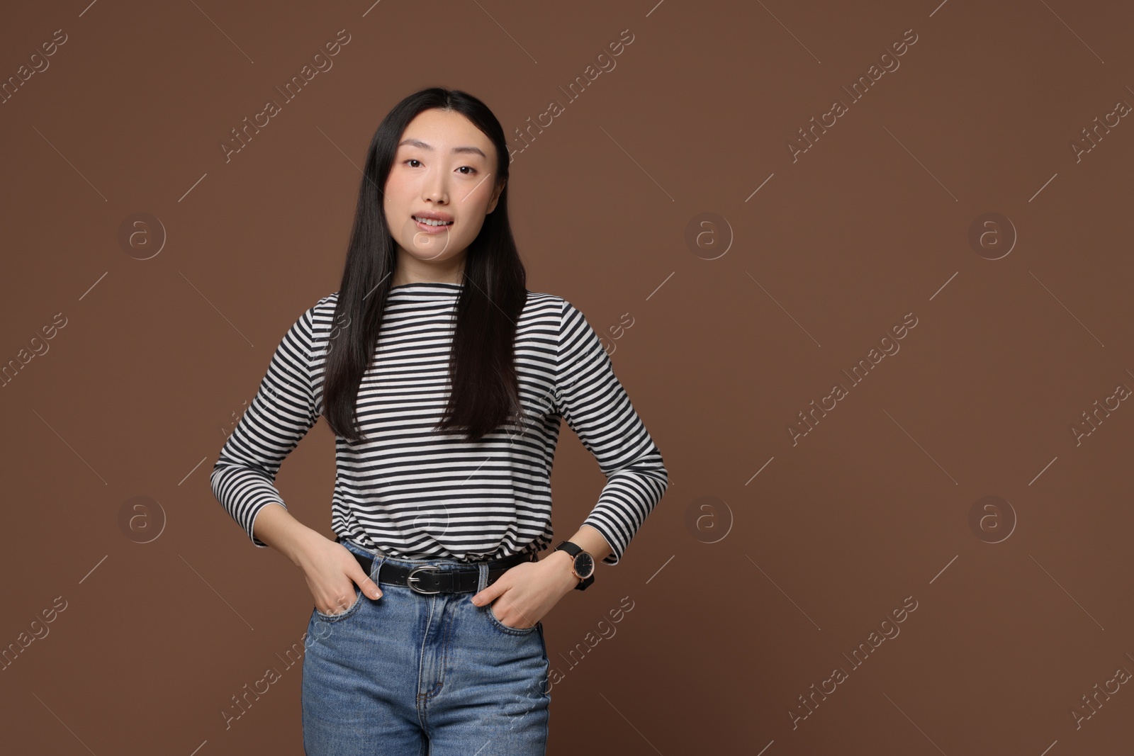 Photo of Portrait of smiling woman on brown background. Space for text