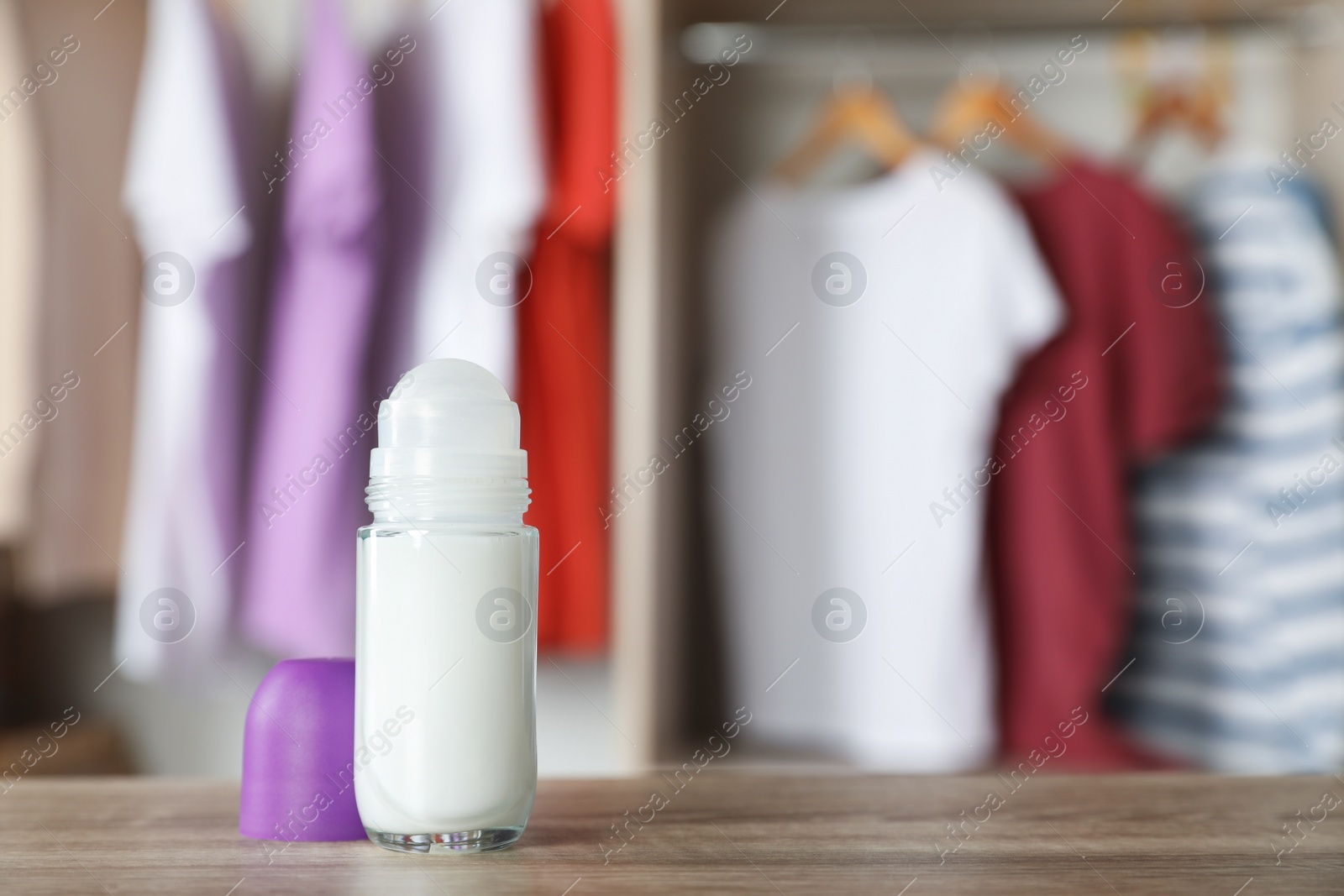 Photo of Deodorant on wooden table indoors. Space for text