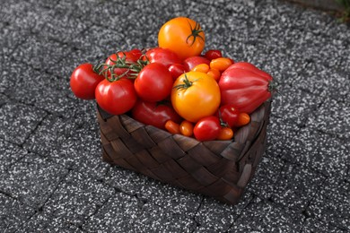 Basket with fresh tomatoes on stone surface