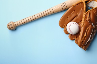 Photo of Baseball glove, bat and ball on pale light blue background, flat lay. Space for text