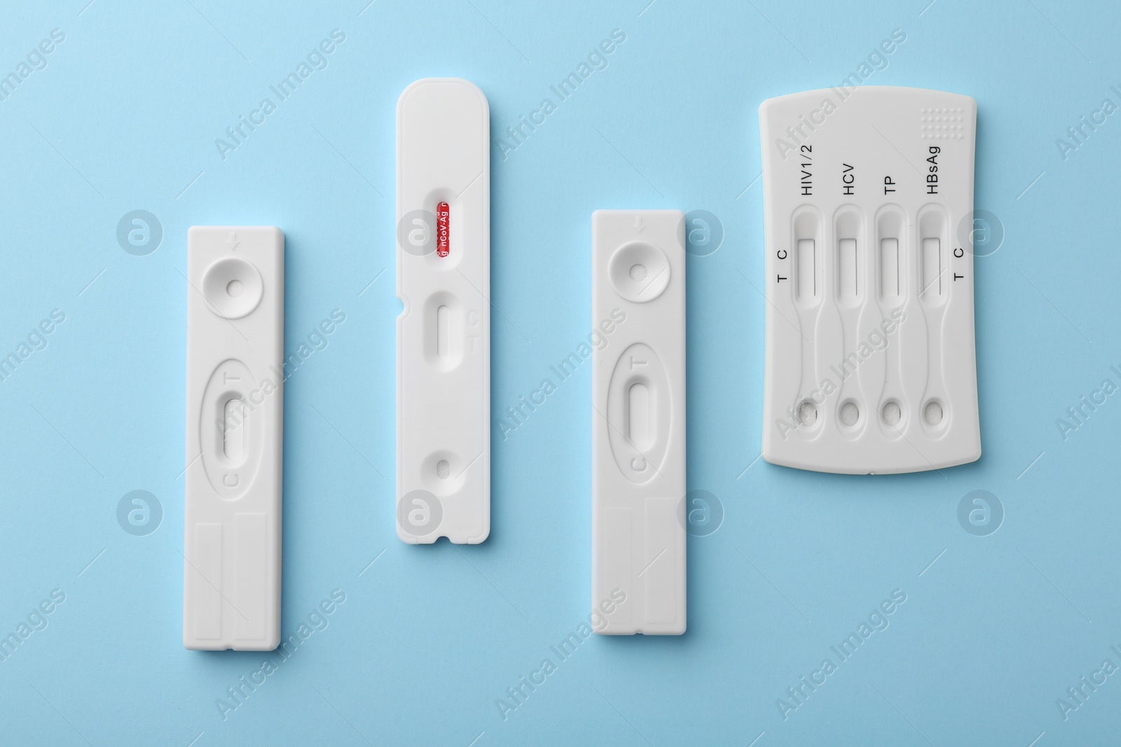 Photo of Different disposable express tests on light blue background, flat lay