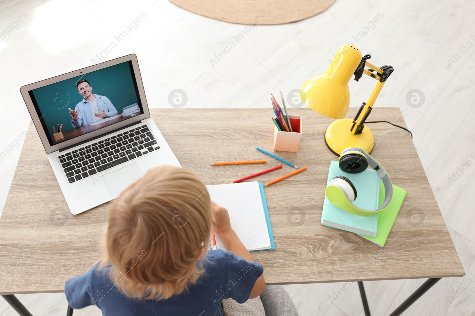 Photo of Little boy studying with teacher via video conference at home. Distance learning during COVID-19 pandemic